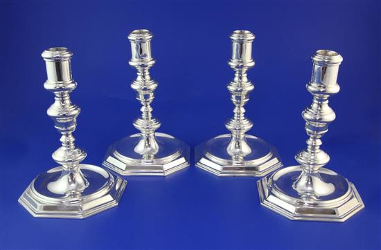 A set of four George V early 18th century style cast silver candlesticks by Goldsmiths & Silversmiths Co Ltd, 51.5 oz.